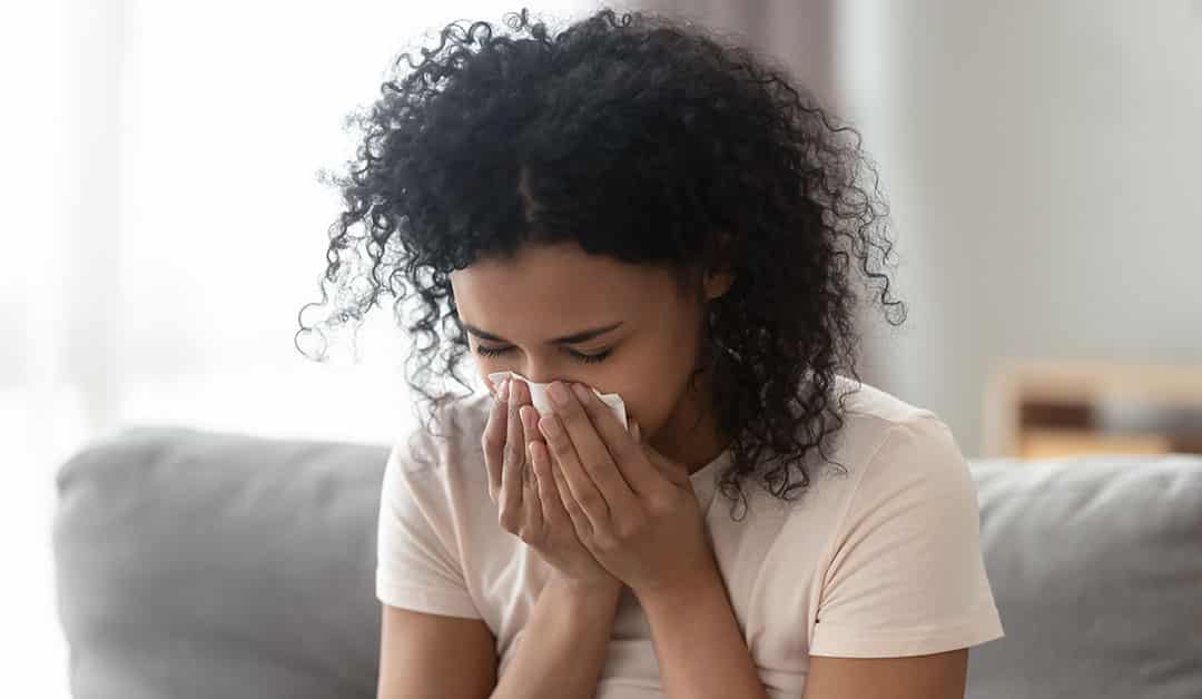 A woman reacting to allergies in her home.